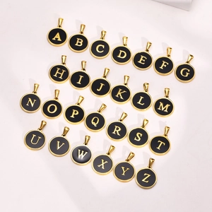 26 round initial pendants in black enamel and 18K gold plated steel on a white background
