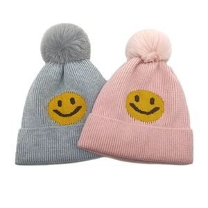 Schicke Strickmütze für Damen mit Smiley-Patch und großem Bommel für den Winter