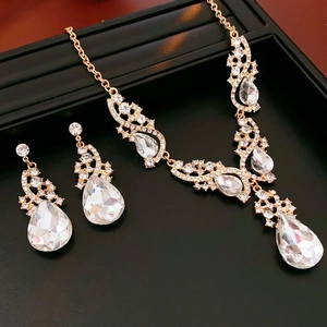 Détail d'une parure de bijoux dorés avec cristaux en forme de poire sur un plateau