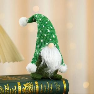 Macro detail of a green knitted Christmas gnome with stars and a long white beard