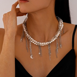 Detail of layered pearl and silver chain necklace with star, moon and fringe tassel drops
