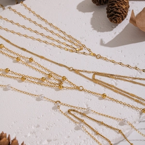 Elegant gold double-layered Y-chain necklace with small beads and white pearls on a white background