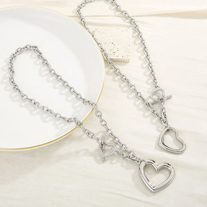 Detail view of hollow heart pendant and OT buckle on stainless steel necklace chains