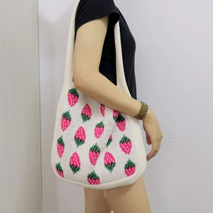 Chic cream knitted tote bag featuring pink strawberry patterns with a woven texture finish