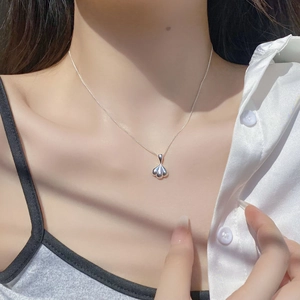 Close-up of S925 sterling silver shell pendant necklace on woman's neckline