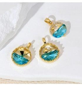 Detailed macro of gold plated pendants with blue stones, star, moon and whale tail
