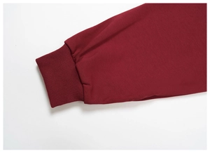 Close-up of ribbed cuffs on burgundy sweatshirt showing high-density knit fabric texture