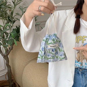 Close-up of model holding blue tulip cotton drawstring storage bag with fabric texture