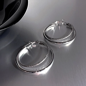 Minimalist double layered silver hoop earrings with a textured and polished finish