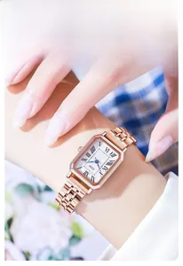 Detail of rose gold square quartz watch with five-link steel band on woman's wrist