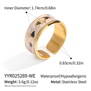 Detail of golden stainless steel ring showing light gray enamel evil eye patterns