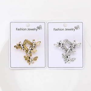 Detail of vintage dragonfly brooches with pearls in gold and silver finishes