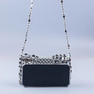 Detail showing internal storage capacity of the silver woven crossbody bag with a smartphone