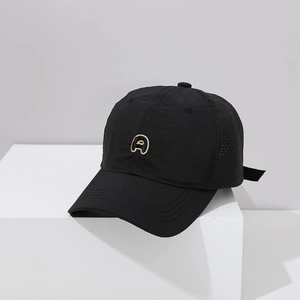 Détail d'une casquette noire séchage rapide avec broderie dorée et œillets respirants