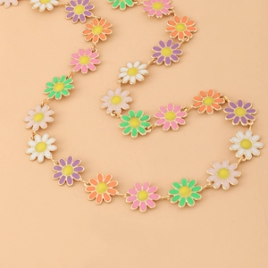 Detailed macro view of colorful daisy enamel charms on a dainty golden link chain necklace
