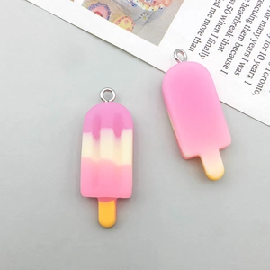 Close-up of pink and yellow gradient resin ice cream charms with metal loops for DIY jewelry