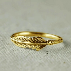 Detailopname van gouden veerring met vintage zirkoon en fijne texturen op de bladeren