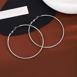 Minimalist large silver hoop earrings on a decorative red and white artistic background