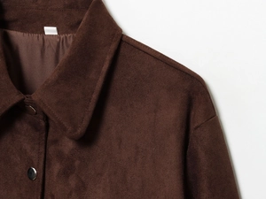 Close-up of brown faux suede jacket collar with metallic buttons and fabric texture