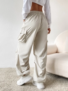 Detail view of high-waisted cargo pants with elastic waist and side flap pockets