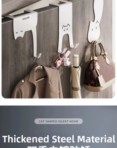 Detail of white cat-shaped over-door hooks made of thickened steel on wood door