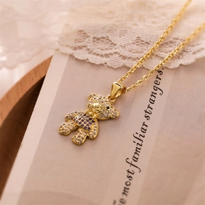 Detail of gold bear necklace pendant with purple and clear zircon stones in macro view