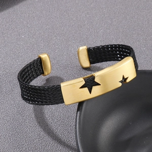 Macro shot of men's C-shaped steel cable bracelet with gold star cutout plate