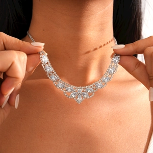 Close-up of silver rhinestone necklace with elegant floral and leaf pattern on model
