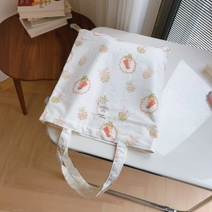 Détail de l'imprimé floral et de l'étiquette en tissu sur le sac cabas en coton