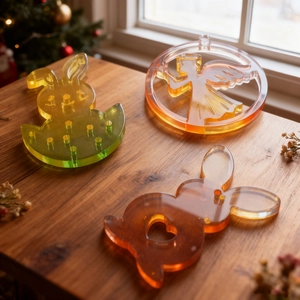 Detail of glossy bunny and angel resin pendants with warm amber transparency