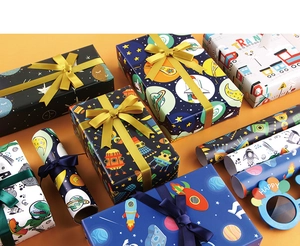 Detailed view of cartoon space and dinosaur gift wrapping paper with navy and gold ribbons