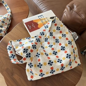 Close-up of floral embroidery on off-white cotton linen tote bag with fabric handle