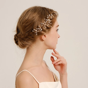 Détail d'épingle à cheveux de mariée dorée avec perles blanches et fleurs délicates