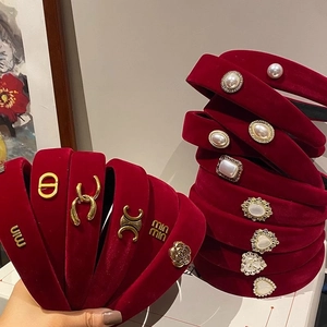 Detail of red velvet braided headbands with pearls, camellias and heart-shaped jewelry