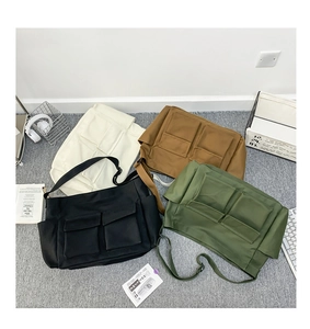 Detailed flat lay of high-capacity canvas messenger bags in four colors with front pockets