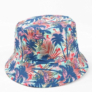 Détail d'un chapeau bob avec imprimé flamant rose et feuilles de palmier sur toile bleue