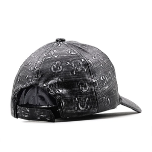 Detail view of the skull embossed pattern and adjustable back strap on the leather baseball cap