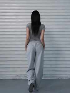 Back view of a grey slim-fit cotton T-shirt and matching high-waist loose joggers