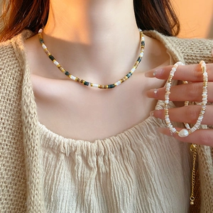 Close-up of gold-plated necklace and bracelet set with freshwater pearls and beads