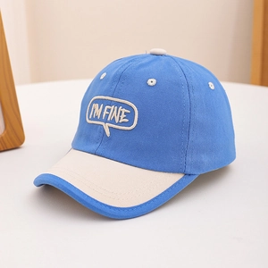 Détail de la casquette enfant bleu et beige avec broderie fine et bord contrasté