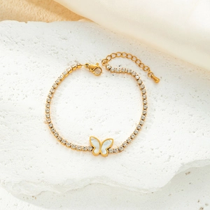 Detailed close-up of golden butterfly bracelet with white crystals and lobster clasp