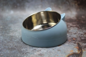 Detail of light blue cat-ear shaped elevated pet bowl with tilted stainless steel insert