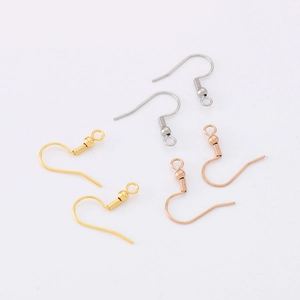 Macro detail of gold, silver, and rose gold stainless steel fish hook earrings with coil