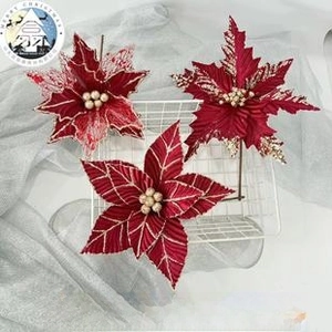 Detail view of shimmering poinsettia flowers with gold glitter and pearl center accents