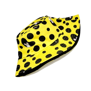 Detailed view of yellow bucket hat with black polka dots and cartoon mouse patterns