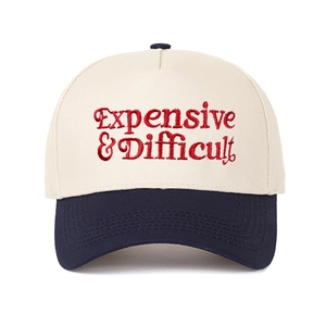 Macro shot of red embroidery on the beige crown and navy blue brim of the baseball cap