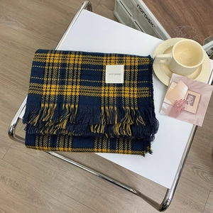 Classic red plaid scarf with tassels on white metal table in a cozy autumn setting