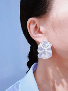Gros plan d'un mannequin portant de grandes boucles d'oreilles vintage en forme de fleur