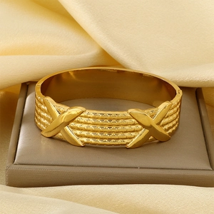 Textured wide 18K gold plated stainless steel bangle with X motifs on silk background