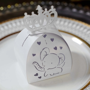 Close-up of laser-cut crown top on white paper gift box with cute elephant print